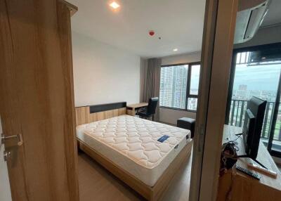 Cozy bedroom with double bed, desk, and balcony view