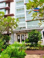 Front view of a residential building surrounded by greenery