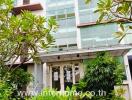 Front view of a residential building surrounded by greenery