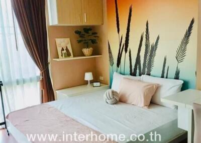 Bedroom with bed, shelves, and nature-themed wall art
