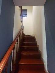 Wooden staircase with railing in a narrow hallway