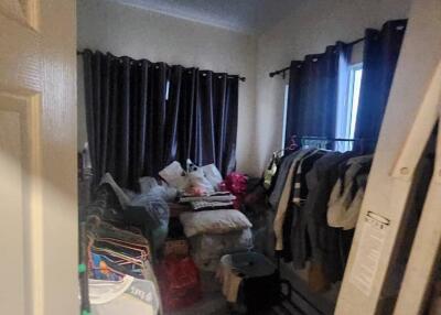 Cluttered bedroom with dark curtains and various personal items