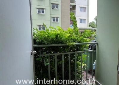 Balcony with a view of neighboring buildings and green foliage