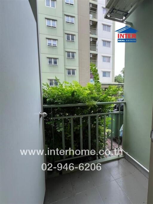 Balcony with a view of neighboring buildings and green foliage