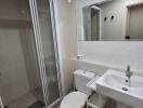 Modern bathroom with shower enclosure, vanity, and toilet