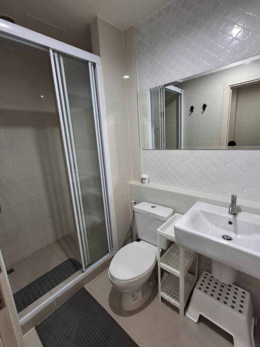 Modern bathroom with shower enclosure, vanity, and toilet