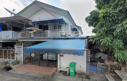 Front view of a residential house with blue awnings