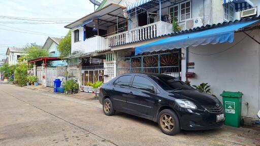 Street view with residential buildings and a parked car