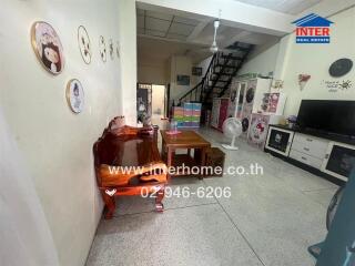 Living room with wooden furniture, stairway, and wall decorations