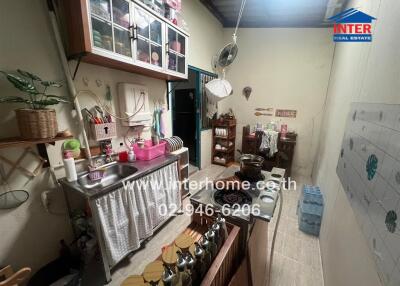 Small kitchen with various household items and cooking utensils