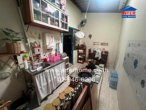 Small kitchen with various household items and cooking utensils