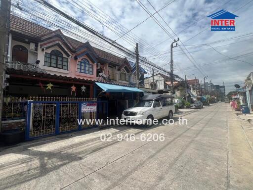 Street view of residential buildings with parked vehicle