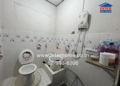 A compact bathroom with tiles and a wall-mounted water heater