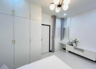Modern bedroom with white wardrobe and study area