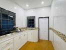 Spacious modern kitchen with wooden flooring and sleek cabinetry