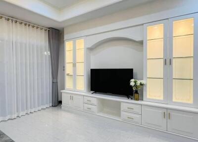 Modern living room with built-in entertainment unit and large window with curtains