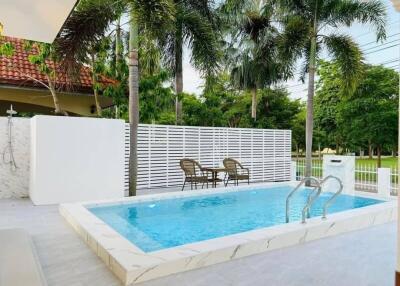 Outdoor swimming pool with patio and palm trees