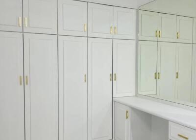 Spacious walk-in closet with built-in wardrobes and dressing table