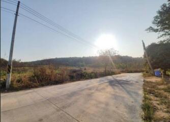 A concrete road with an open field in the daytime