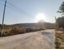 A concrete road with an open field in the daytime