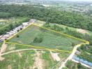 Aerial view of a large triangular plot of land surrounded by greenery