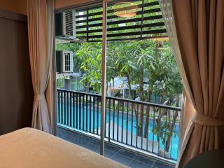 Bedroom with a view of the pool and garden