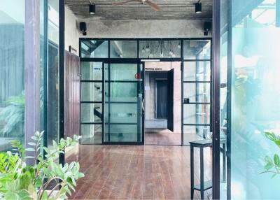 Modern industrial-style entrance with glass doors and wooden flooring