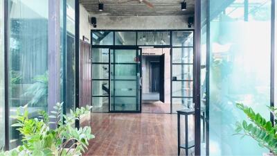 Modern industrial-style entrance with glass doors and wooden flooring