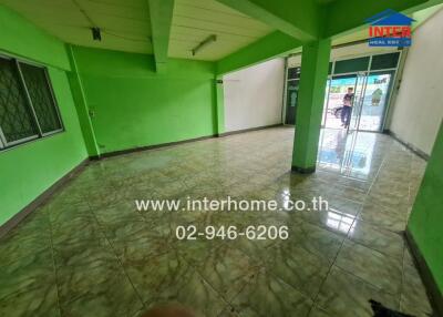 Spacious empty living area with tiled floors and green walls