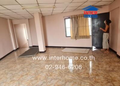 Spacious living room with tile flooring and natural lighting