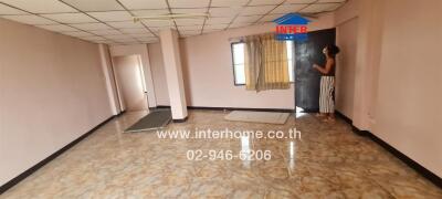 Spacious living room with tile flooring and natural lighting