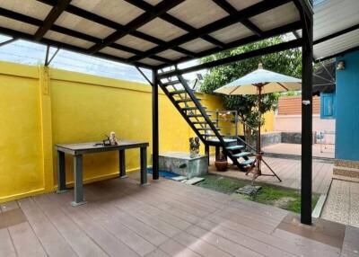 Covered patio area with table and stairs