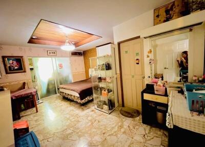 Well-lit bedroom with tiled floor, bed, and sliding glass closet