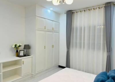 Spacious bedroom with built-in wardrobes and decorative curtains