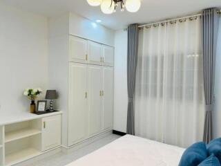 Spacious bedroom with built-in wardrobes and decorative curtains