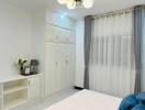 Spacious bedroom with built-in wardrobes and decorative curtains