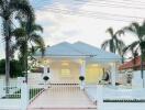 Modern white house with front yard and palm trees