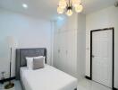Modern bedroom with single bed, white wardrobes, and ceiling light