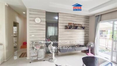 Modern living room with wall-mounted shelves, glass table, and balcony view