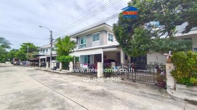 Two-story residential building with surrounding houses