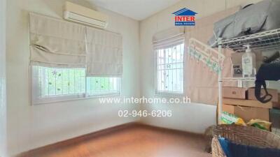 Bedroom with air conditioning, windows, and wooden floor