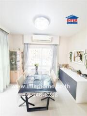 Dining room with glass table, white chairs, and decorative elements