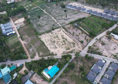 Aerial view of a residential area with adjacent plots of land