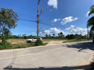 Open land plot with some vegetation and a parked car