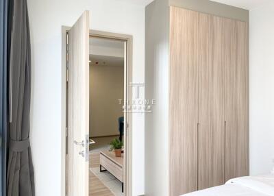 Bedroom with open door leading to an adjacent room and a wooden wardrobe