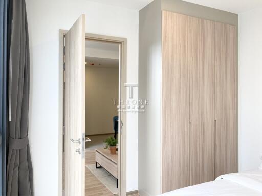 Bedroom with open door leading to an adjacent room and a wooden wardrobe