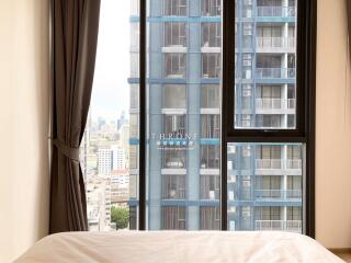 bedroom with a large window view of modern urban high-rise buildings