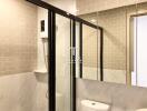 Modern bathroom with a glass shower and tiled walls