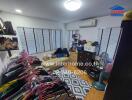 Bedroom with clothes rack, air conditioner, fan, rug, and shelves