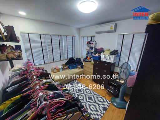 Bedroom with clothes rack, air conditioner, fan, rug, and shelves